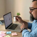 person brainstorming niche ideas for affiliate marketing using laptop and sticky notes